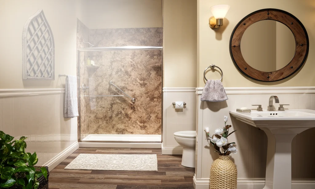 Walk-in shower with a clear glass enclosure, brown stone-look wall panels, grab bars and a white shower base